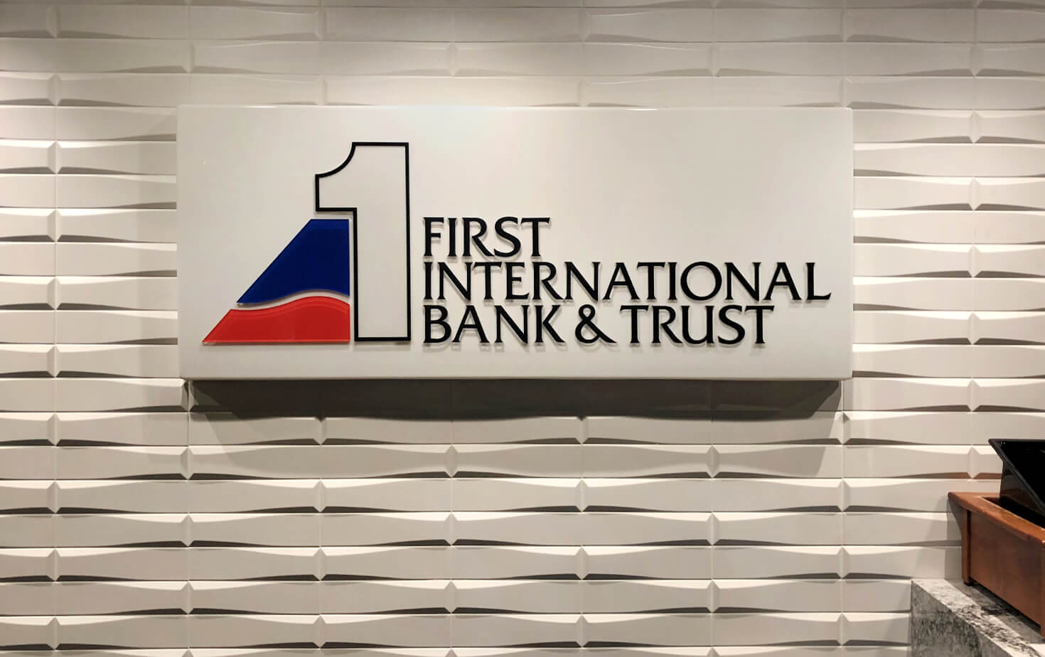 First International Bank and Trust Interior Logo Wall Sign Illuminated mounted on textured wall