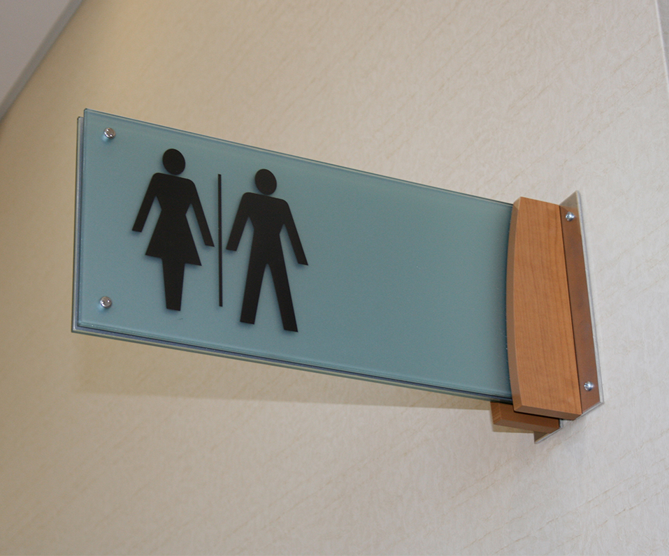 Maple Grove Hospital Flag Mounted ADA bathroom sign with wood and acrylic accents