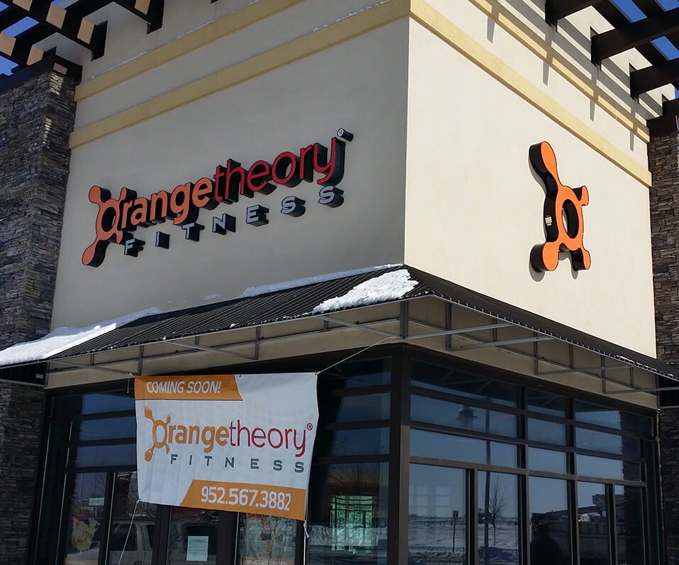 Orangetheory fitness building front with channel letters on left corner custom shaped logo on right Apple Valley MN