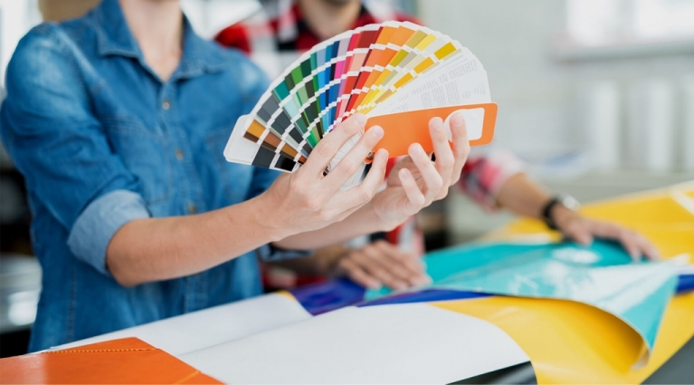 Crop view of young man and woman exploring palette of colors and choosing shades 
